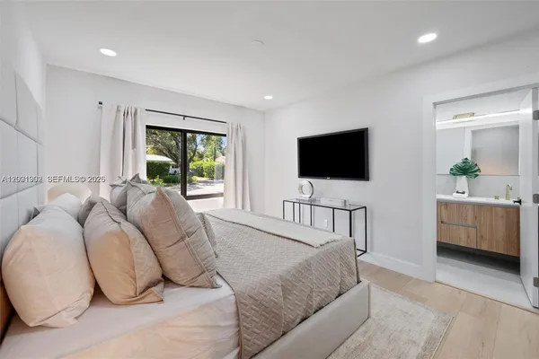 a bedroom with a bed tv and a window