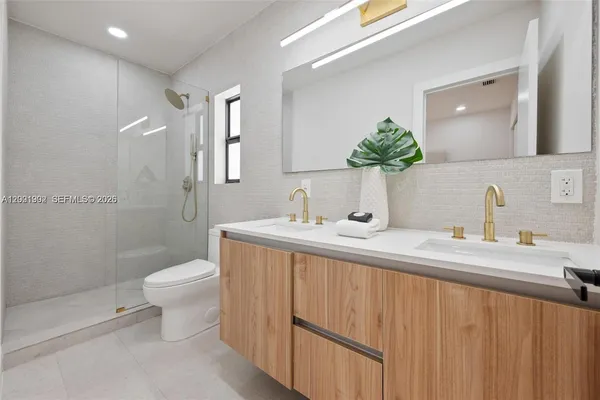 a bathroom with a double vanity sink toilet and shower
