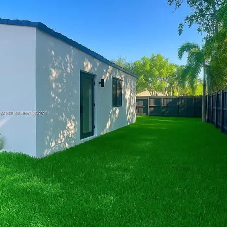 a view of a house with a big yard and potted plants