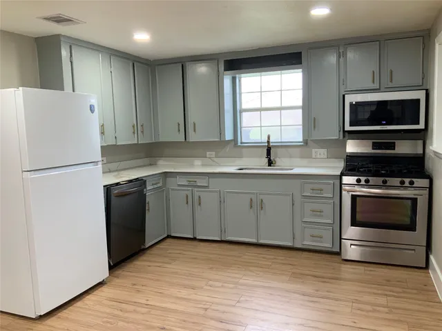 a kitchen with a sink stove and refrigerator