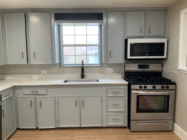 a kitchen with cabinets appliances and a sink
