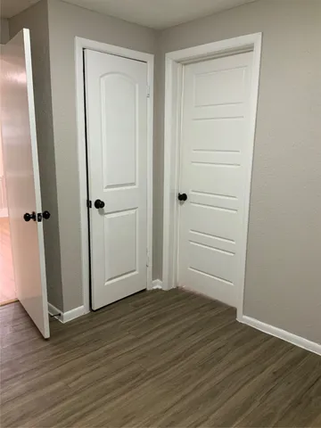 an empty room with wooden floor and closet area
