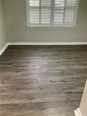 a view of a room with wooden floor and a window