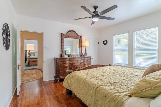 a bedroom with a bed and a mirror on the dresser