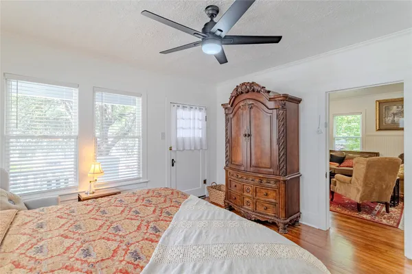 a spacious bedroom with a bed a dresser and a window