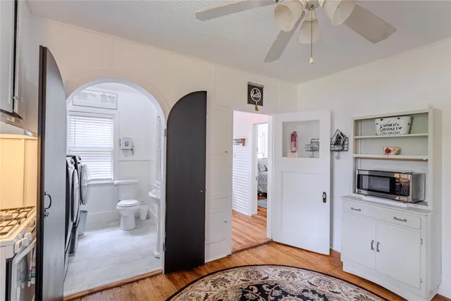 a view of a hallway with bathroom and wooden floor