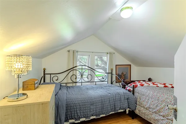 a bedroom with a bed a dresser and potted plants
