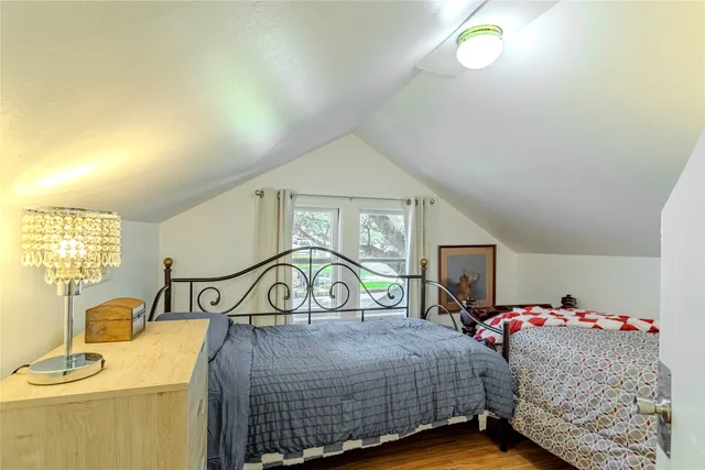 a bedroom with a bed a dresser and potted plants
