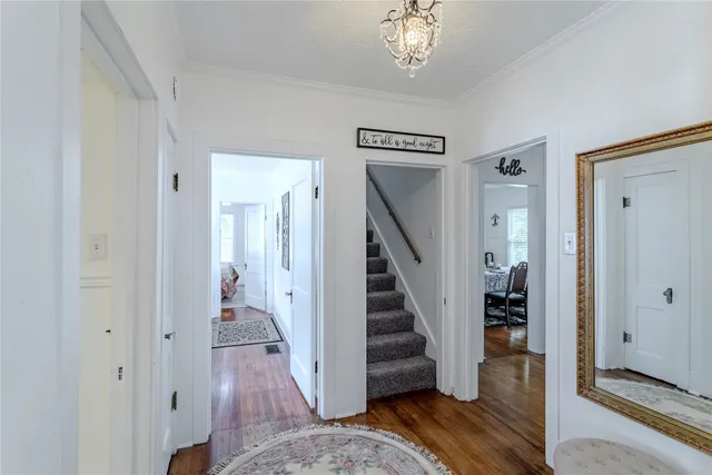 a view of a hallway with wooden floor and staircase