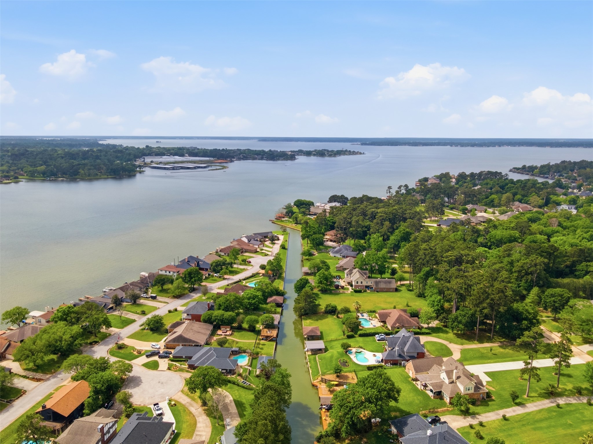 12710 Aries Loop Willis, TX 77318 - Photo 40 of 40 Aerial view of the community, showcasing waterfront properties, private docks, and a tree-lined canal, with extensive green spaces
