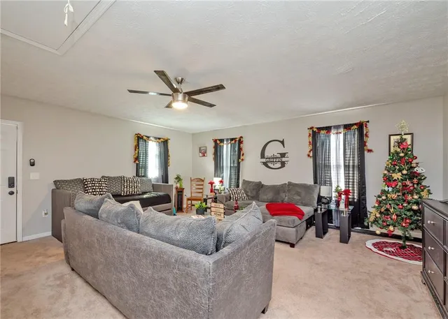 a living room with furniture chess table and a ceiling fan