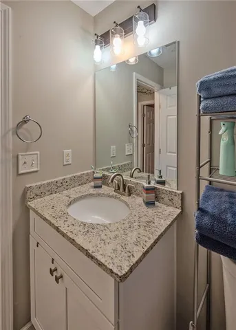 a bathroom with a granite countertop sink and a mirror