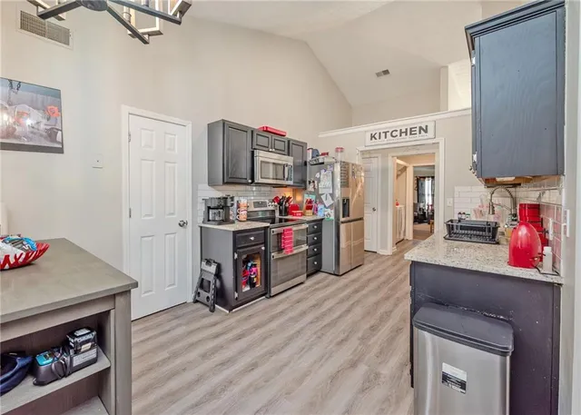 a kitchen with stainless steel appliances a stove cabinets and wooden floor