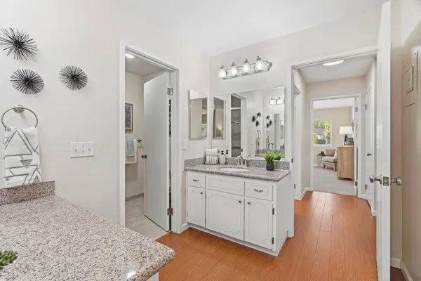a spacious bathroom with a granite countertop sink a mirror and shower
