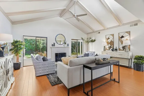 a living room with furniture a fireplace and a large window