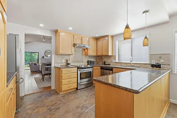 a kitchen with a stove kitchen island and stainless steel appliances