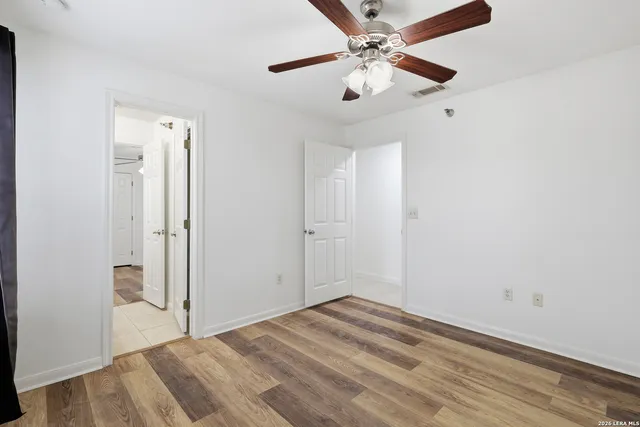 an empty room with a window and a ceiling fan