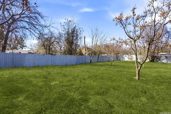 a view of a house with a big yard and large trees