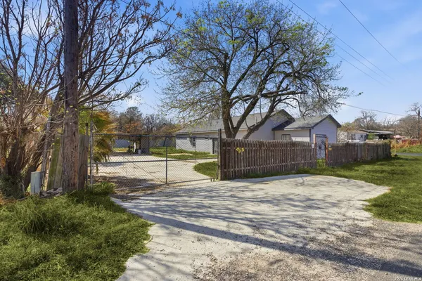 a view of a house with a big yard and palm trees