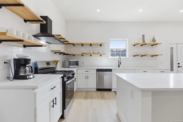 a kitchen with a sink a stove and cabinets