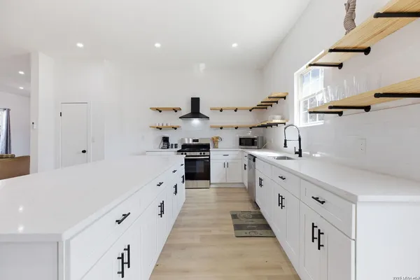 a large white kitchen with stainless steel appliances