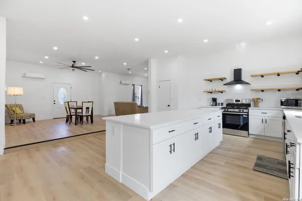 a large kitchen with stainless steel appliances a large counter top a sink a stove and a refrigerator