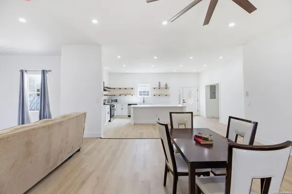 a living room with furniture and a dining table with kitchen island