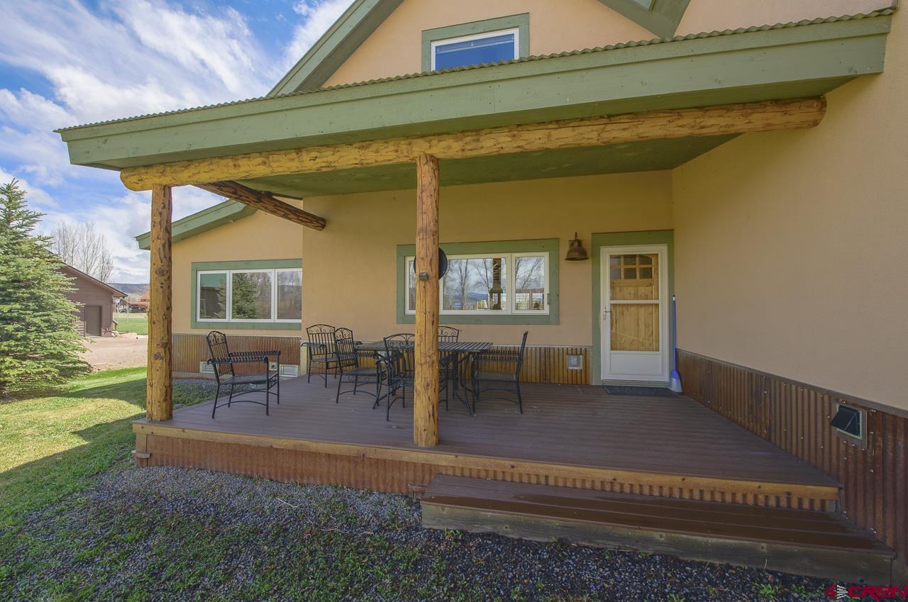 157 Spring Meadow Trail Gunnison, CO 81230 - Photo 11 of 43 Covered back porch, North facing toward Ohio Creek and overlooking the grassy lawn and raised bed gardens.