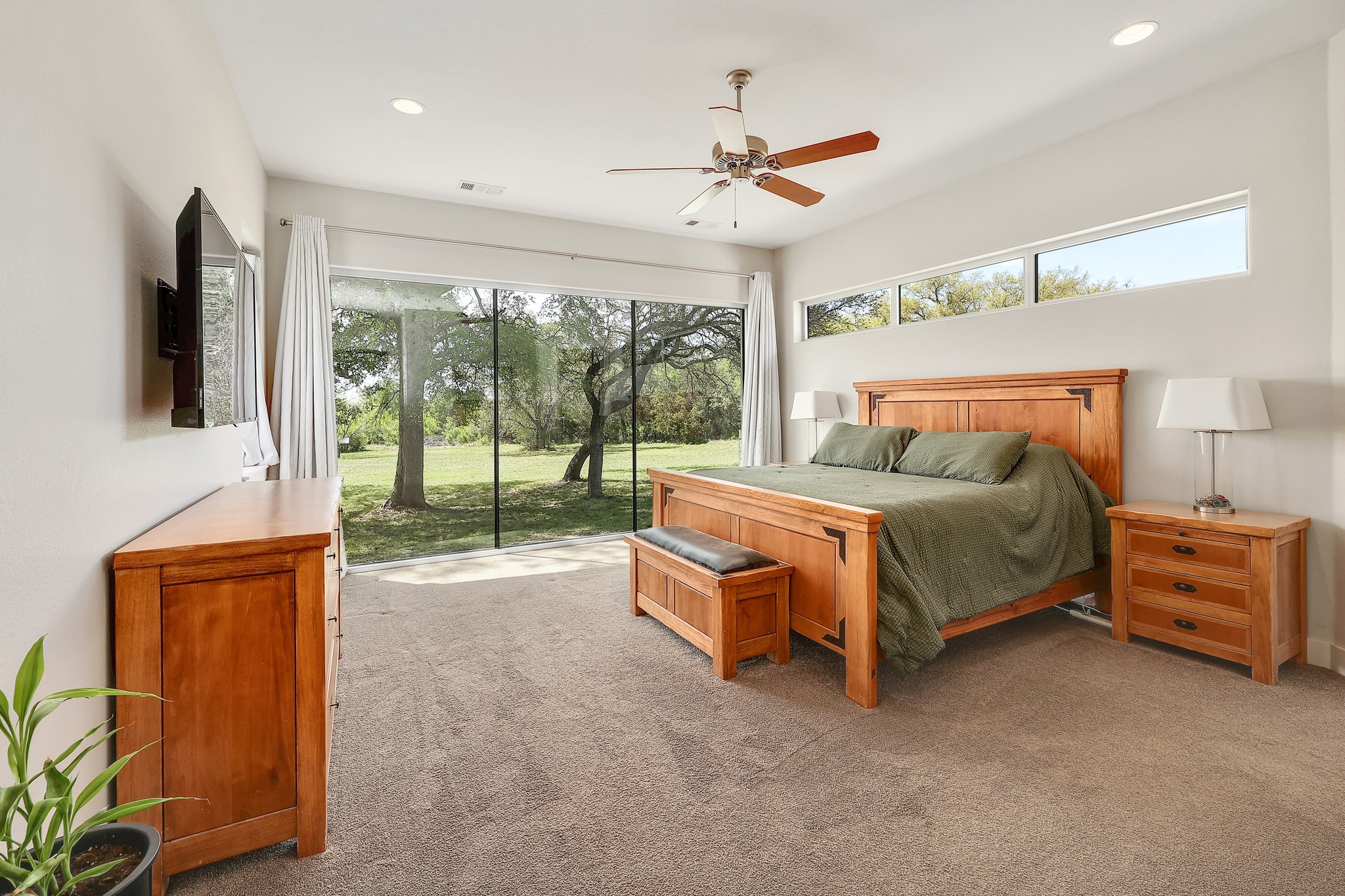 23928 Oscar Road Spicewood, TX 78669 - Photo 16 of 39 a spacious bedroom with a bed and a chandelier