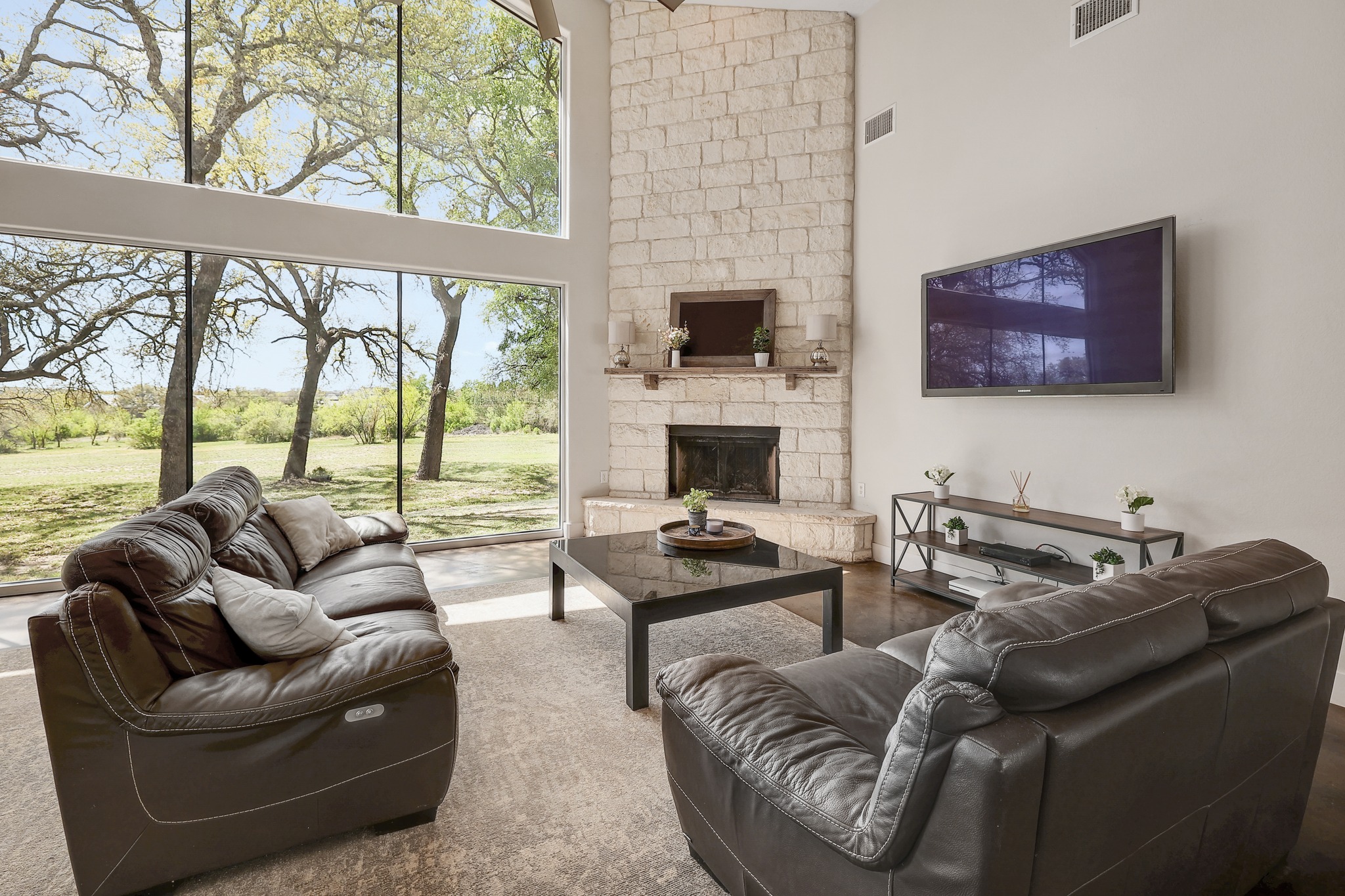 23928 Oscar Road Spicewood, TX 78669 - Photo 4 of 40 a living room with furniture a flat screen tv and a floor to ceiling window