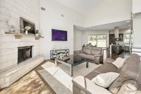 a view of a dining room with furniture one side kitchen view and wooden floor