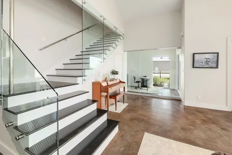 a kitchen with stainless steel appliances kitchen island granite countertop a refrigerator a stove a sink a dining table and chairs with wooden floor