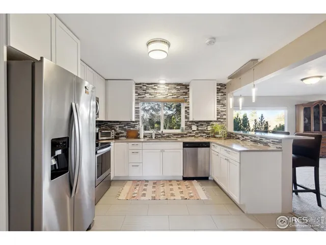 a kitchen with a refrigerator and white cabinets