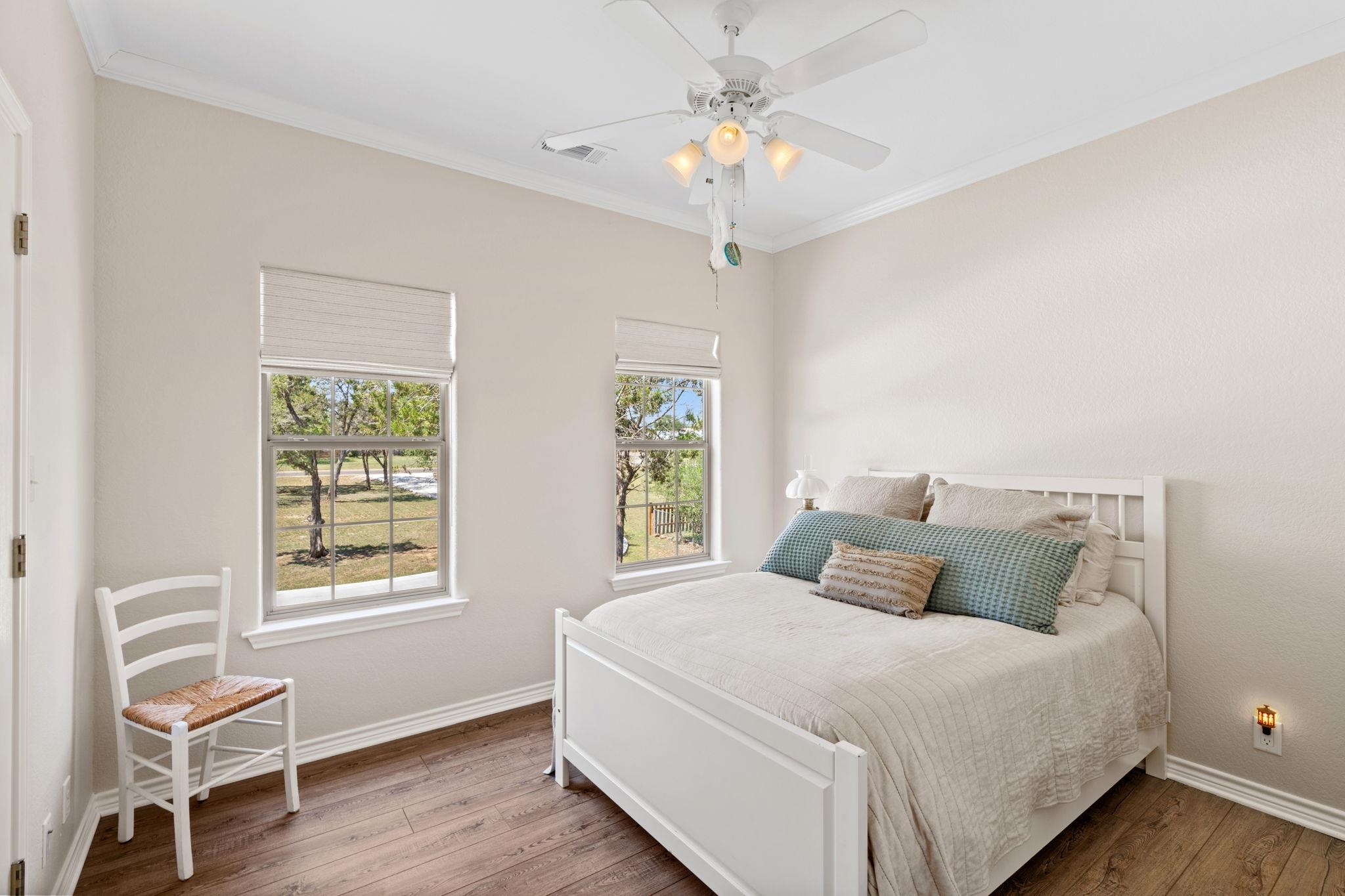 2409 Mormon Mill Road Marble Falls, TX 78654 - Photo 11 of 30 a bedroom with a chandelier and a window
