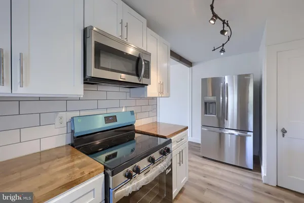 a kitchen with kitchen island a counter space a sink and stainless steel appliances