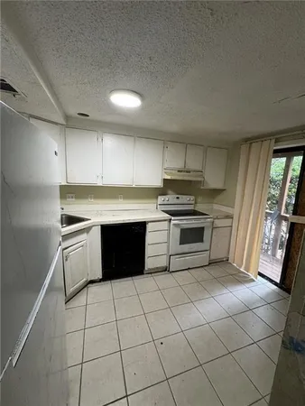 a kitchen with a stove sink and cabinets