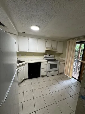 a kitchen with a stove sink and cabinets