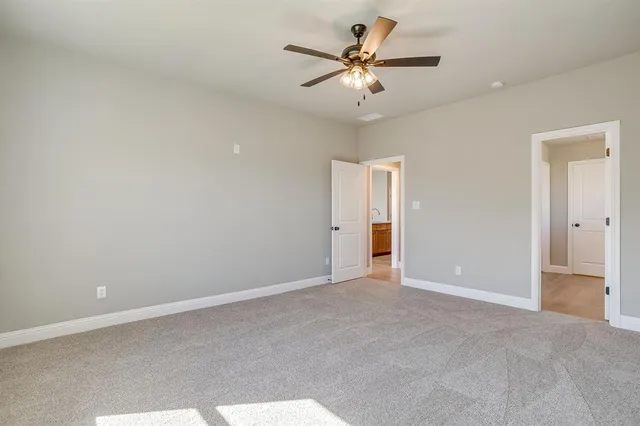 an empty room with a ceiling fan and a window