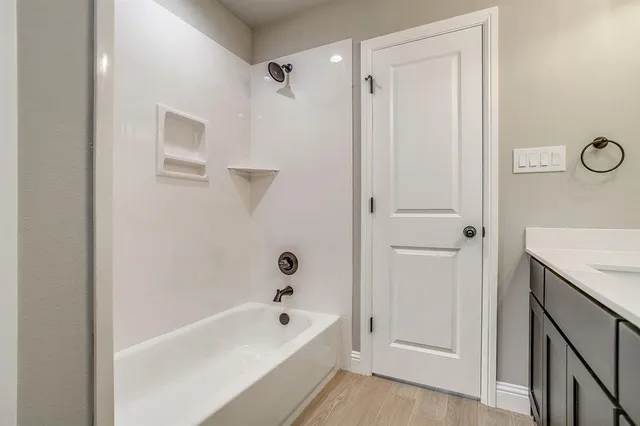 a bathroom with a tub shower and sink