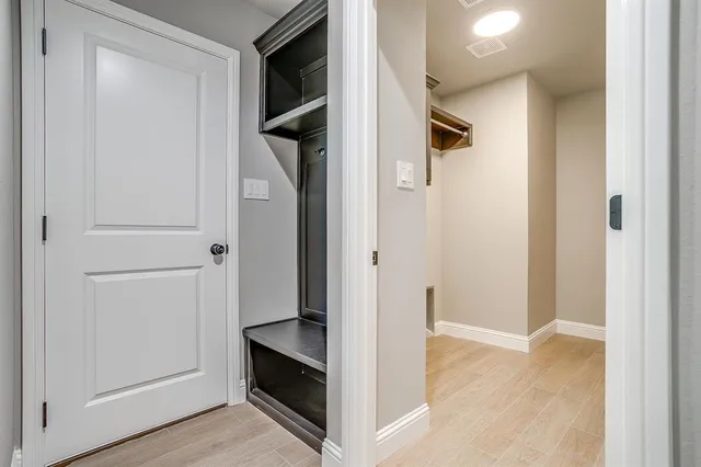 a view of a hallway with wooden floor and closet