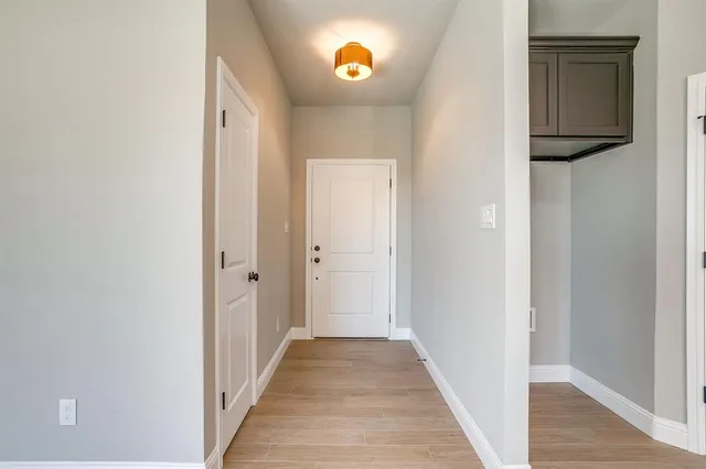 a view of a hallway with wooden floor and a entryway