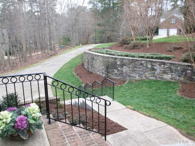 5305 Woodlaurel Court Raleigh, NC 27613 - Photo 2 of 25 This view is from the front porch looking out over the lovely landscaped front yard. Gorgeous stone wall with plantings of shrubs and trees on one side of driveway, other side you can see nice buffer of trees between the homes that offer privacy.