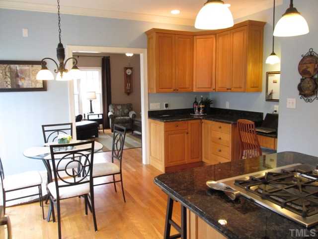 5305 Woodlaurel Court Raleigh, NC 27613 - Photo 11 of 25 Vew of kitchen with breakfast area features hardwood flooring, updated stainless steel appliances, granite, secretary's desk, gas cooktop, under cabinet lighting, can lighting, lazy susan, roll out drawers! Major expense for buyers already done!