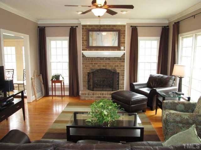 5305 Woodlaurel Court Raleigh, NC 27613 - Photo 12 of 25 Family room features ceiling fan with light kit, eyeball lighting, real fireplace with gas logs, raised hearth, hardwood floors, lots of natural light in this room makes for a wonderful place to sit and read your favorite book or periodical.