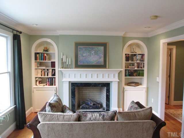 5305 Woodlaurel Court Raleigh, NC 27613 - Photo 16 of 25 First floor master suite sitting area in bedroom features lovely custom built arched bookshelves with decorative only fireplace, can lighting, hardwood floors, is on main floor of your home, has office, bath, and walk-in closet as well!