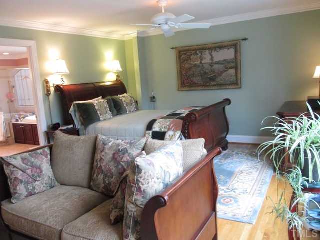 5305 Woodlaurel Court Raleigh, NC 27613 - Photo 17 of 25 First floor master suite view shows the sleeping and sitting area. The settee is facing the decorative only fireplace and in the left hand side of the picture you can see the master bath. This suite has its own entrance, office, walk-in closet, and more!