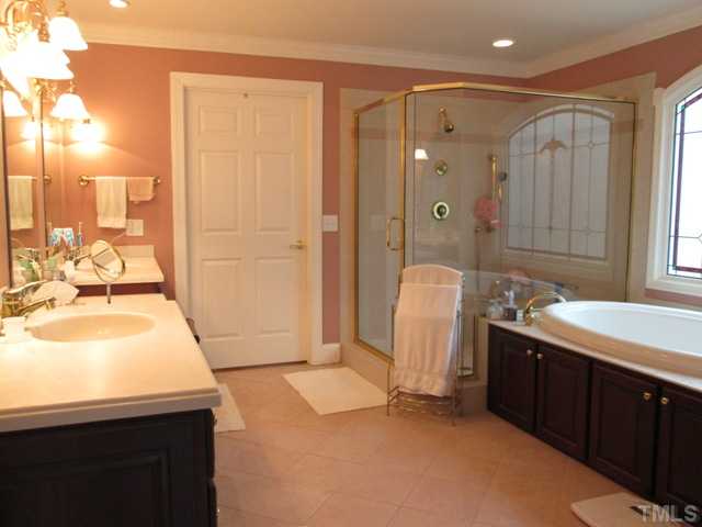 5305 Woodlaurel Court Raleigh, NC 27613 - Photo 18 of 25 First floor master bath suite has garden tub, walk in separate shower, arched glass window, cultured marble double sink vanity, tile floor installed on the 45 degree angle, enclosed water closet, plenty of room for 2 people to get ready at the same time!
