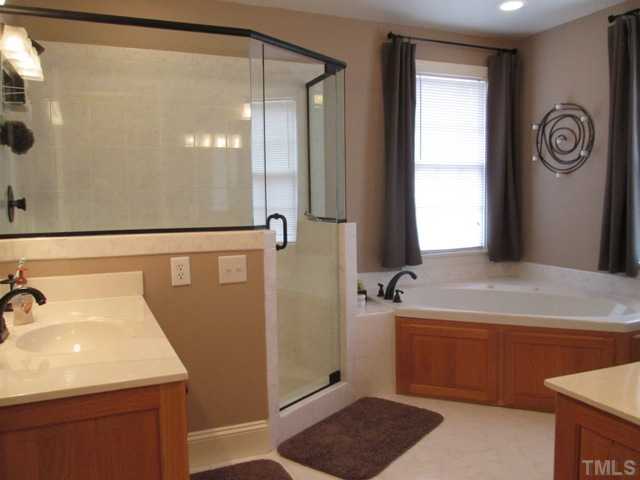 5305 Woodlaurel Court Raleigh, NC 27613 - Photo 22 of 25 Second floor master bath features all new rubbed bronze fixtures, corner jetted garden tub, walk in separate shower, tile floor and two separates vanities! All this has been updated! Major expense already done for the buyer!