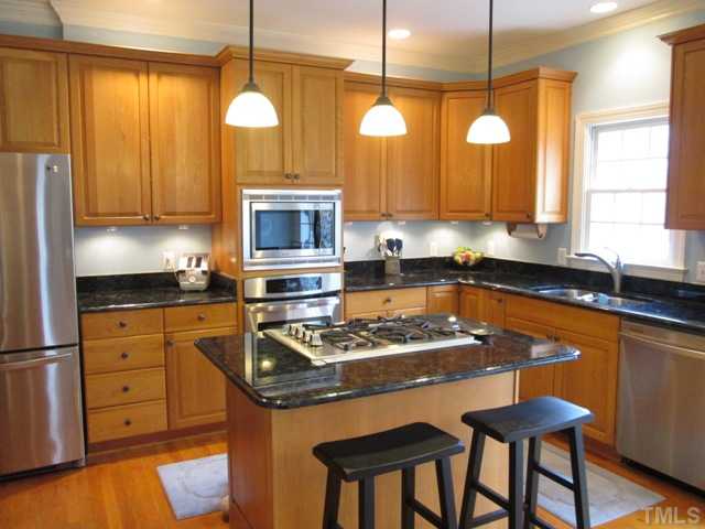 5305 Woodlaurel Court Raleigh, NC 27613 - Photo 10 of 25 Kitchen has updated stainless steel appliances, updated hardware, gas cooktop in kitchen island that features granite and pendant lighting above, convection microwave, wall oven, stainless steel dishwasher, all so conveniently & perfectly laid out!