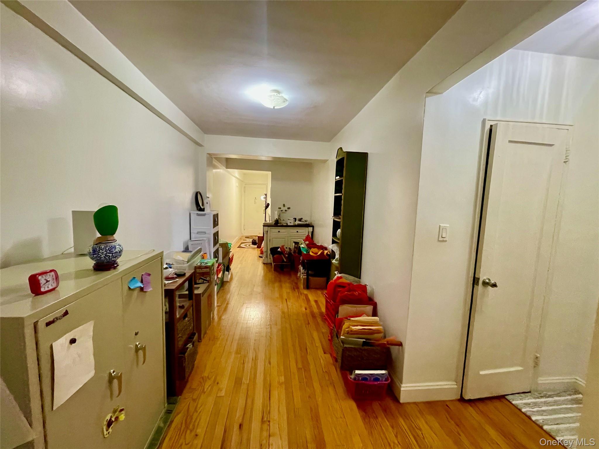 134-33 Blossom Avenue, Unit 3B Queens, NY 11355 - Photo 4 of 7 a living room with furniture and a wooden floor